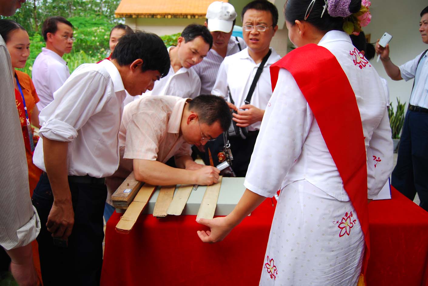 visitors writing on palm leaves